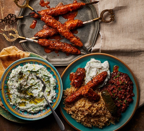 Adana kebabs served with cacik and ezme on the side