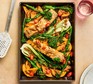A roasting tin with salmon fillets and vegetables