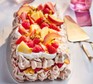 Brown sugar pavlova topped with fruit and served on a plate