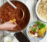 Burnt aubergine veggie chilli in a large pot with rice