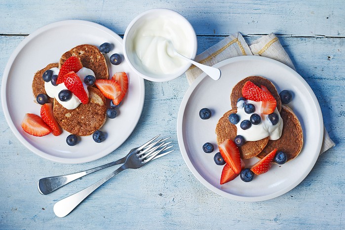 dairy-free-banana-oat-pancakes Two plates of pancakes with yogurt and berries