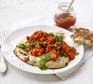 Red lentil & squash dhal on a naan bread on a white plate