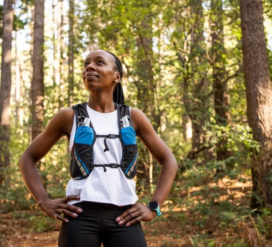 Confident woman cross country runner on forest trail - source: Getty