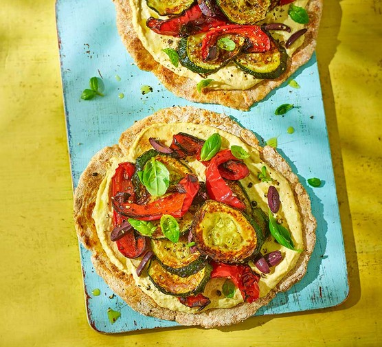 Two hummus flatbread pizzas with roasted veg