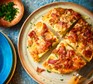 Slices of air-fryer loaded frittata with bacon & cheddar on a serving plate
