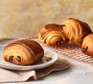 Several pain au chocolat on a cooling rack
