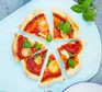 Vegetarian pizza with homemade tomato sauce, mozzarella and basil, cut into slices