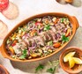 Pork with cucumber & apricot couscous served in a large dish