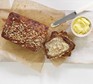 Healthy banana bread sliced with butter on a wooden board