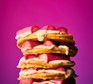 Stack of fluffy pancakes topped with custard and forced rhubarb