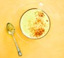 Latte with turmeric topping in cup with spoon