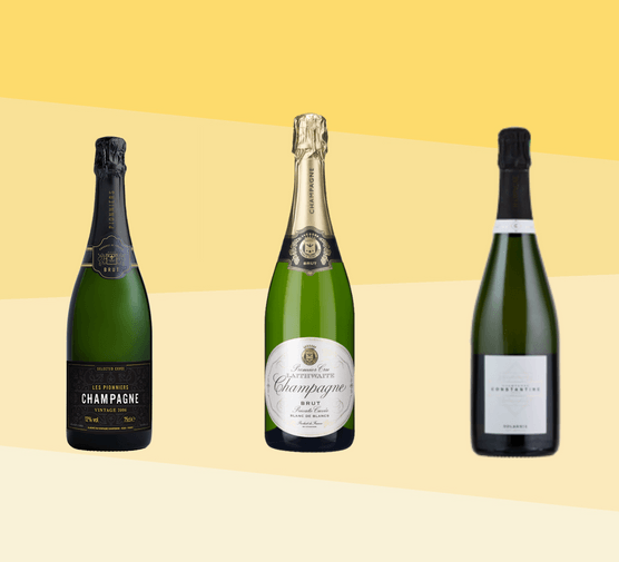 Three champagne bottles in a row with a yellow background